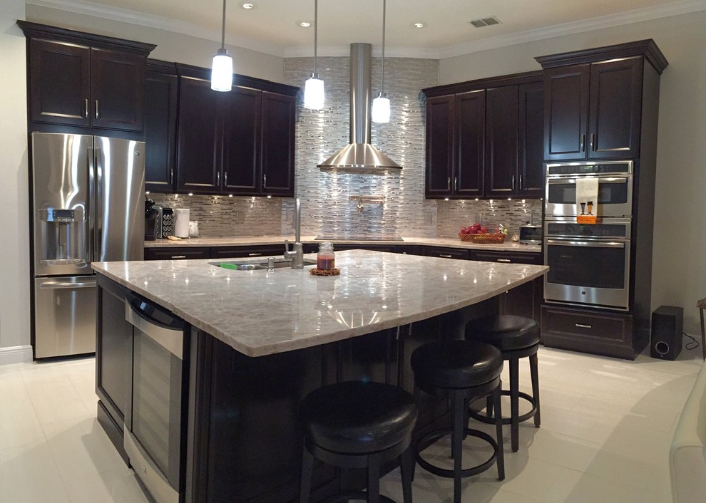 Example of a mid-sized transitional l-shaped porcelain tile and beige floor eat-in kitchen design in Orlando with a double-bowl sink, shaker cabinets, black cabinets, metallic backsplash, glass sheet backsplash, stainless steel appliances, an island and quartz countertops
