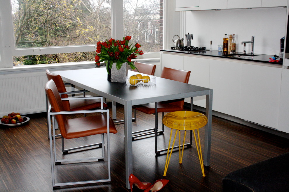 Moderne Wohnküche mit flächenbündigen Schrankfronten und weißen Schränken in Amsterdam