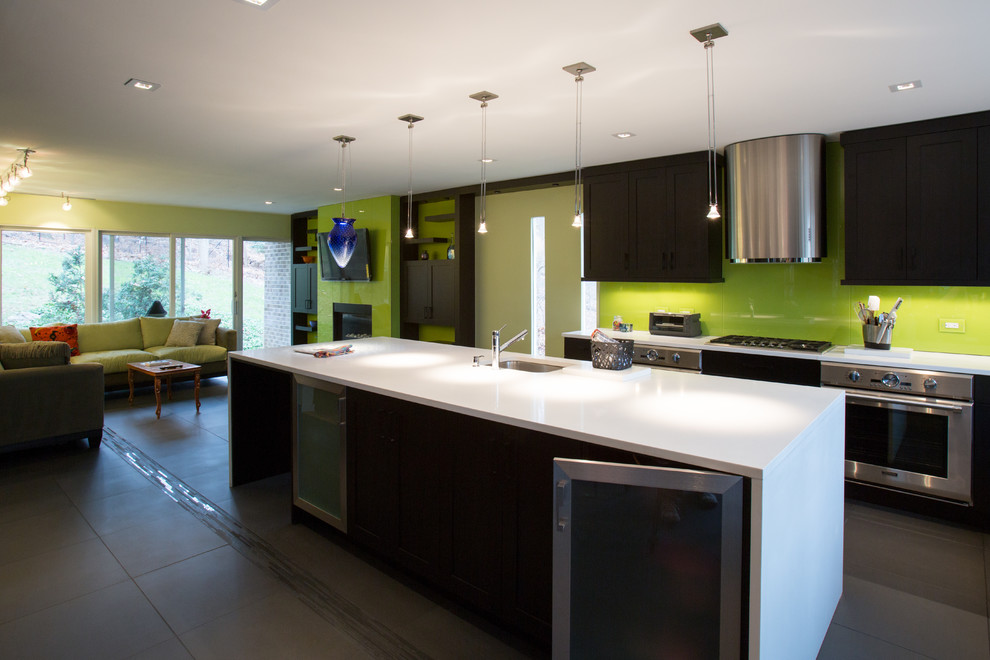 Example of a large minimalist l-shaped ceramic tile open concept kitchen design in DC Metro with an undermount sink, flat-panel cabinets, dark wood cabinets, solid surface countertops, white backsplash, glass sheet backsplash, stainless steel appliances and an island