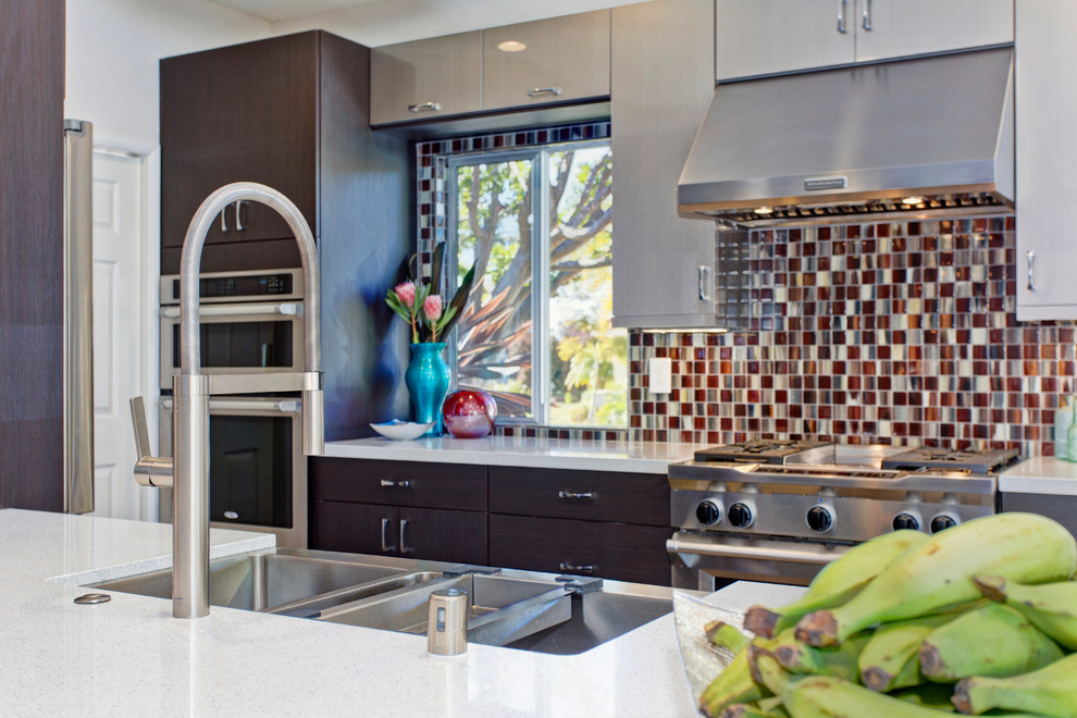 Cette image montre une cuisine américaine parallèle design en bois foncé avec un évier de ferme, un placard à porte plane, un plan de travail en quartz modifié, une crédence multicolore et un électroménager en acier inoxydable.