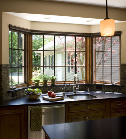 Bild på ett mellanstort vintage kök, med en undermonterad diskho, luckor med infälld panel, skåp i mörkt trä, granitbänkskiva, flerfärgad stänkskydd, stänkskydd i mosaik, rostfria vitvaror och en köksö