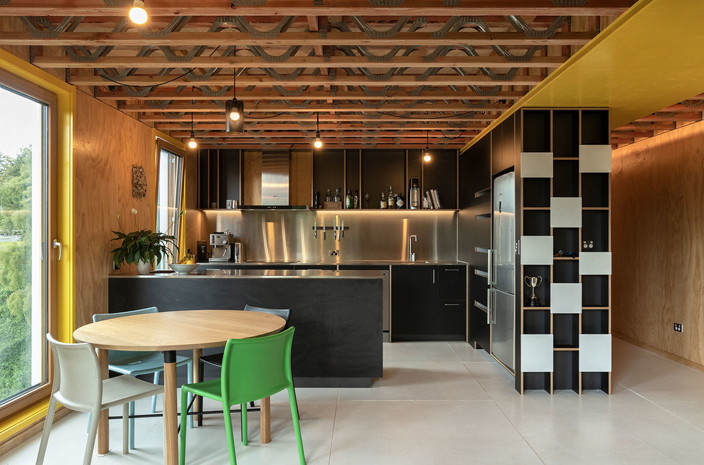 Exempel på ett modernt grå grått kök, med släta luckor, svarta skåp, bänkskiva i rostfritt stål, grått stänkskydd, rostfria vitvaror, en halv köksö, vitt golv och en integrerad diskho