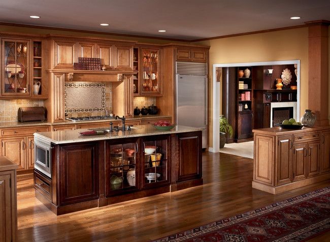Inredning av ett klassiskt mellanstort kök, med en undermonterad diskho, luckor med upphöjd panel, skåp i mellenmörkt trä, granitbänkskiva, beige stänkskydd, stänkskydd i keramik, rostfria vitvaror, mellanmörkt trägolv och en köksö