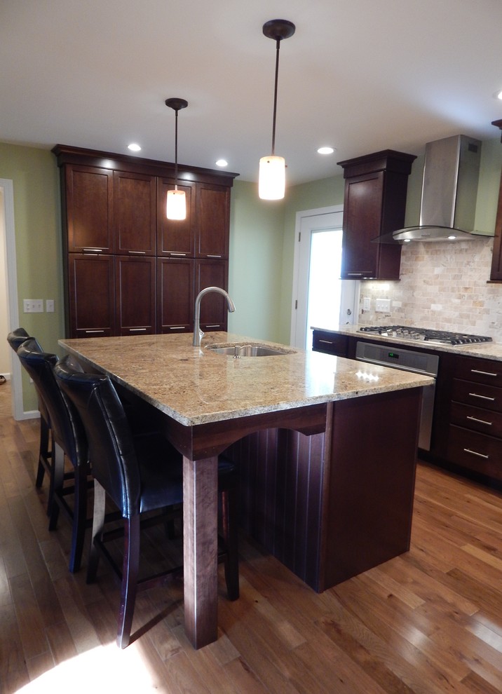 Example of a mid-sized trendy u-shaped medium tone wood floor eat-in kitchen design in Boston with an undermount sink, recessed-panel cabinets, dark wood cabinets, granite countertops, multicolored backsplash, stone tile backsplash, stainless steel appliances and an island