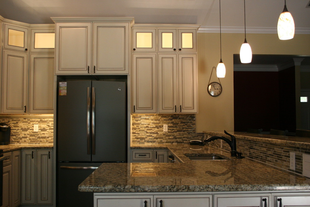 Exempel på ett mellanstort klassiskt kök, med en dubbel diskho, luckor med upphöjd panel, vita skåp, granitbänkskiva, flerfärgad stänkskydd, stänkskydd i mosaik, en halv köksö och rostfria vitvaror