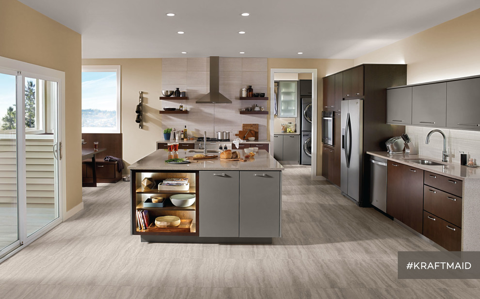 Design ideas for a medium sized contemporary l-shaped kitchen/diner in Detroit with flat-panel cabinets, grey cabinets, stainless steel appliances, light hardwood flooring and an island.