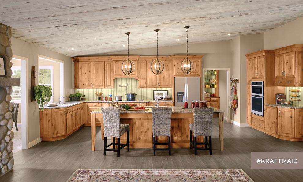 Inspiration for a large rural l-shaped kitchen/diner in Detroit with raised-panel cabinets, medium wood cabinets, green splashback, stainless steel appliances, dark hardwood flooring, an island and a single-bowl sink.