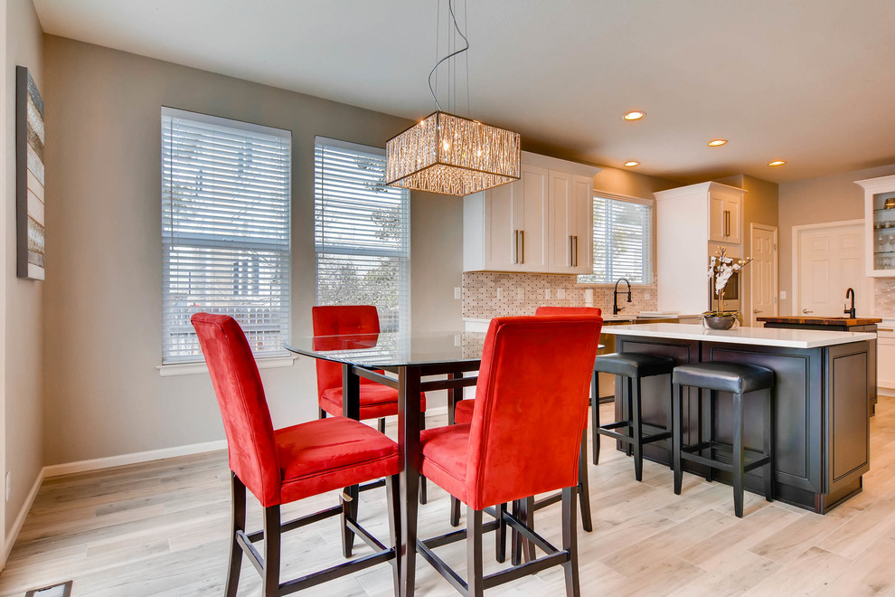 Example of a small transitional l-shaped laminate floor and gray floor eat-in kitchen design in Denver with a farmhouse sink, flat-panel cabinets, white cabinets, quartzite countertops, white backsplash, ceramic backsplash, stainless steel appliances, two islands and white countertops