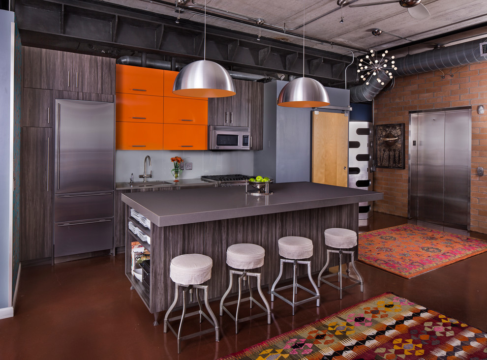 Foto di una cucina contemporanea di medie dimensioni con lavello sottopiano, ante lisce, ante arancioni, top in granito, paraspruzzi blu, paraspruzzi con piastrelle di vetro, elettrodomestici in acciaio inossidabile e pavimento in cemento
