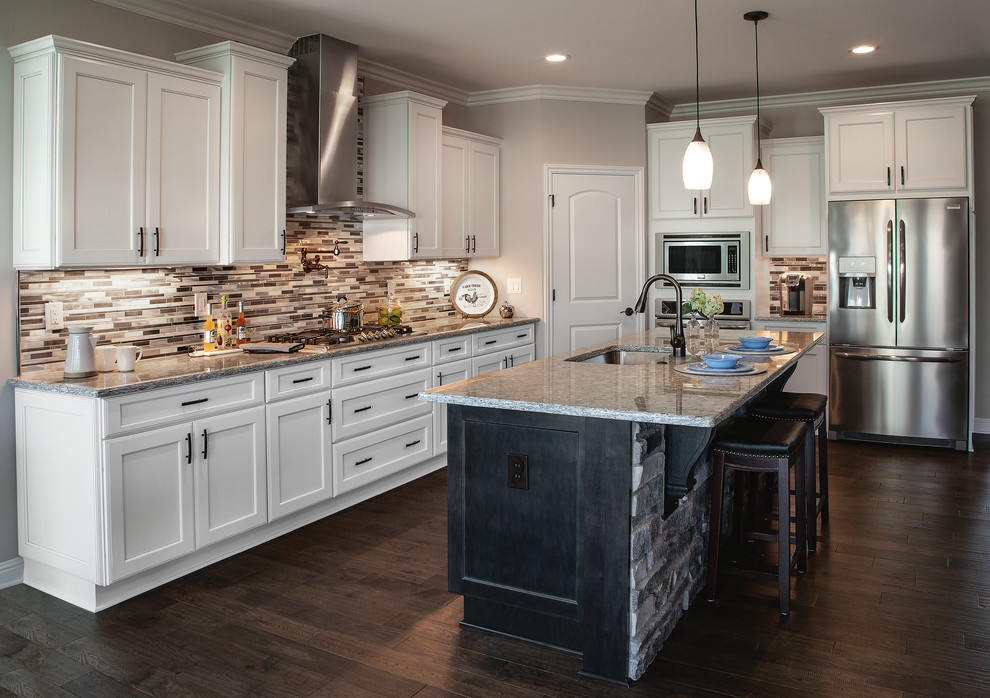Transitional l-shaped dark wood floor and brown floor eat-in kitchen photo in Other with an undermount sink, shaker cabinets, white cabinets, granite countertops, beige backsplash, glass tile backsplash, stainless steel appliances, an island and beige countertops