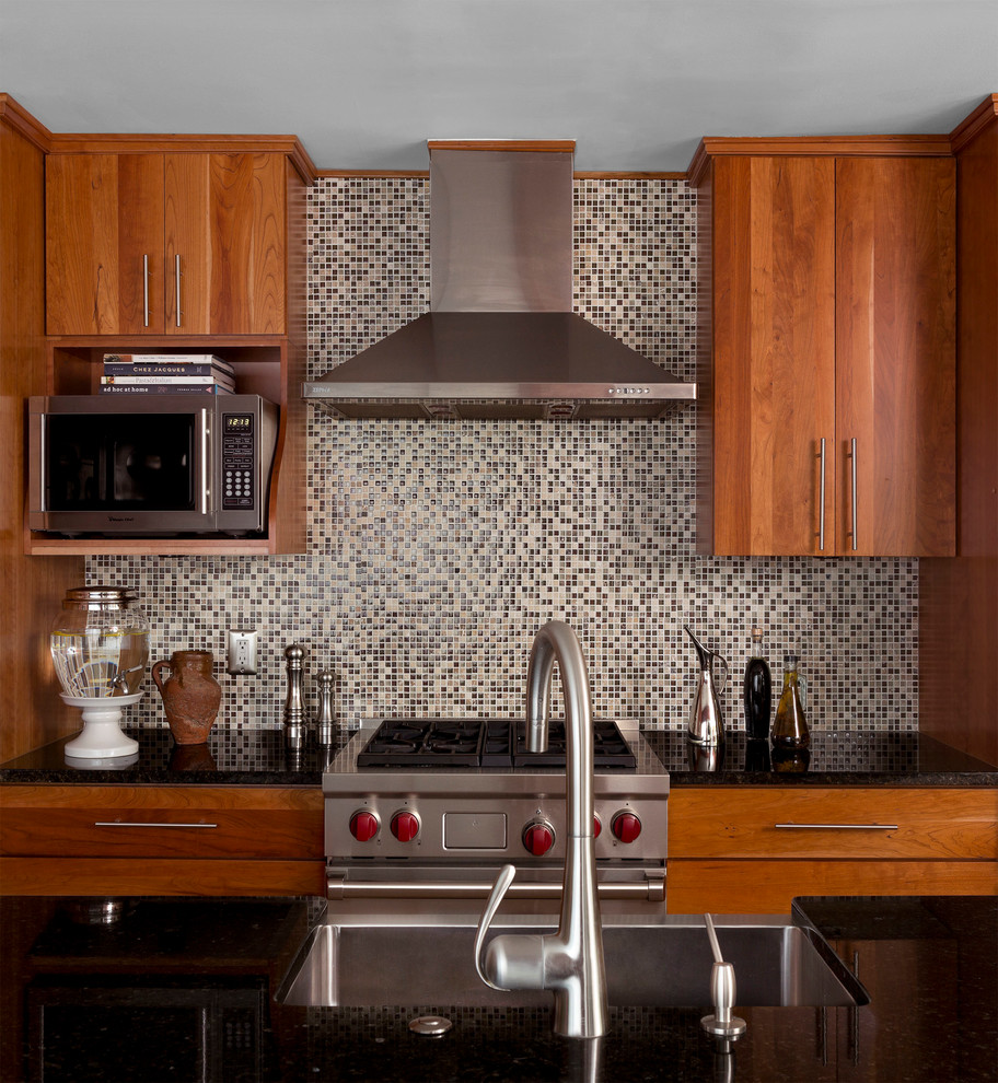 Inredning av ett modernt linjärt kök och matrum, med släta luckor, skåp i ljust trä, flerfärgad stänkskydd, stänkskydd i mosaik och rostfria vitvaror