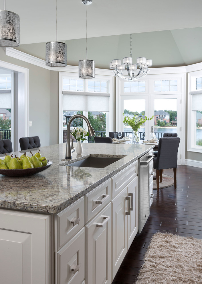 Example of a large transitional galley dark wood floor eat-in kitchen design in Other with an undermount sink, raised-panel cabinets, gray cabinets, beige backsplash, stone tile backsplash, stainless steel appliances, an island and quartz countertops