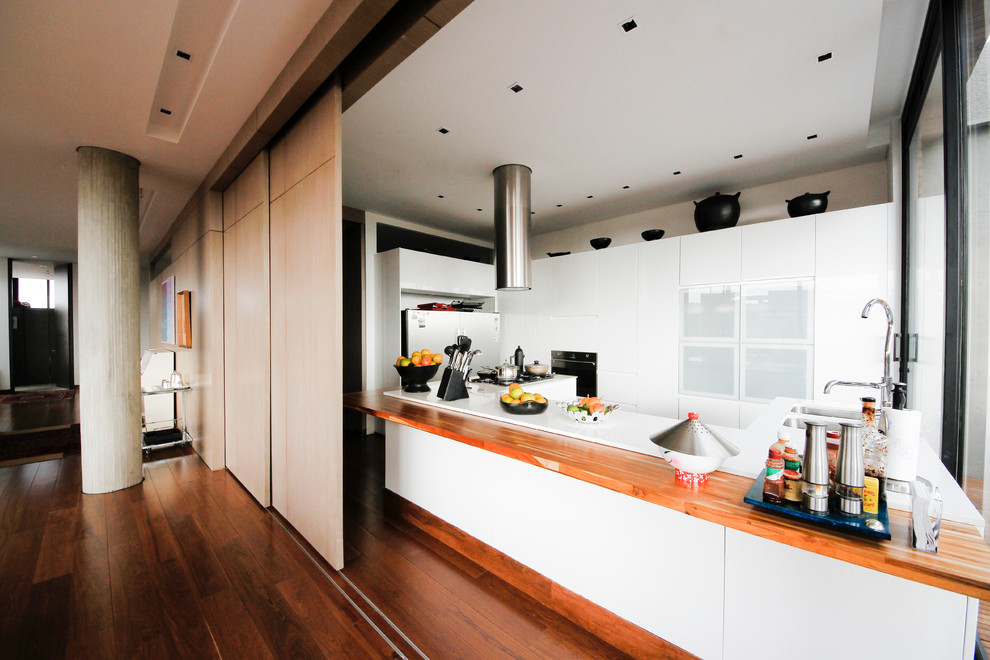 Immagine di una cucina contemporanea con lavello a doppia vasca, ante lisce, ante bianche, top in legno e elettrodomestici bianchi