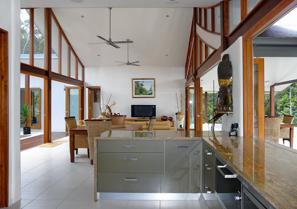 Immagine di una cucina tropicale di medie dimensioni con ante lisce, top in granito e pavimento in gres porcellanato