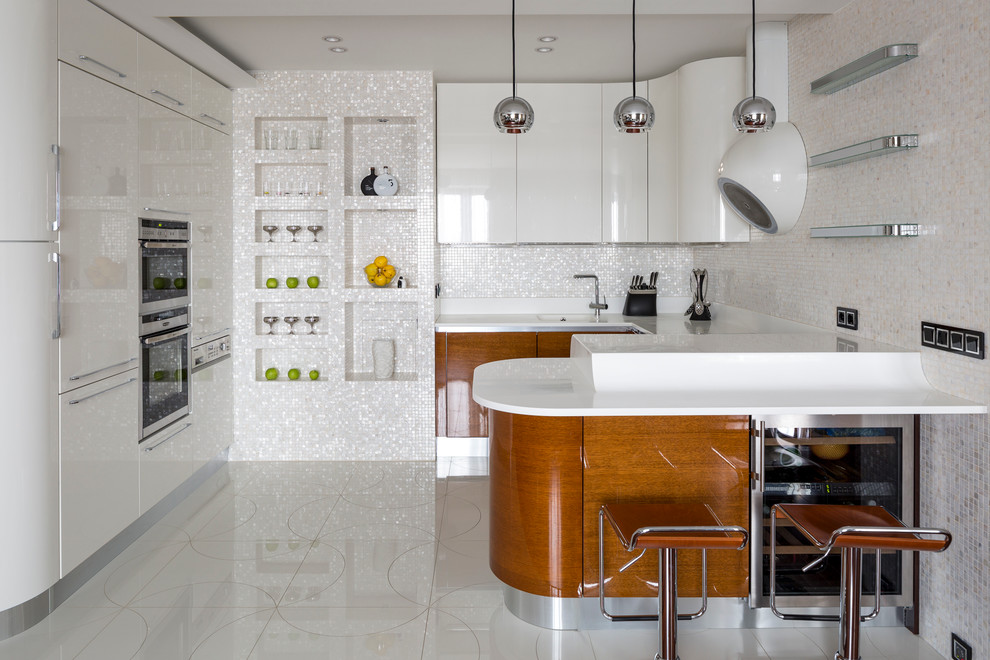 Пример оригинального дизайна: п-образная кухня-гостиная в современном стиле с монолитной мойкой, плоскими фасадами, фартуком из плитки мозаики, техникой из нержавеющей стали, полуостровом, белым фартуком и барной стойкой