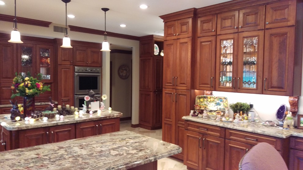 Example of a large tuscan u-shaped marble floor and beige floor kitchen pantry design in Phoenix with an undermount sink, raised-panel cabinets, brown cabinets, granite countertops, stainless steel appliances and an island