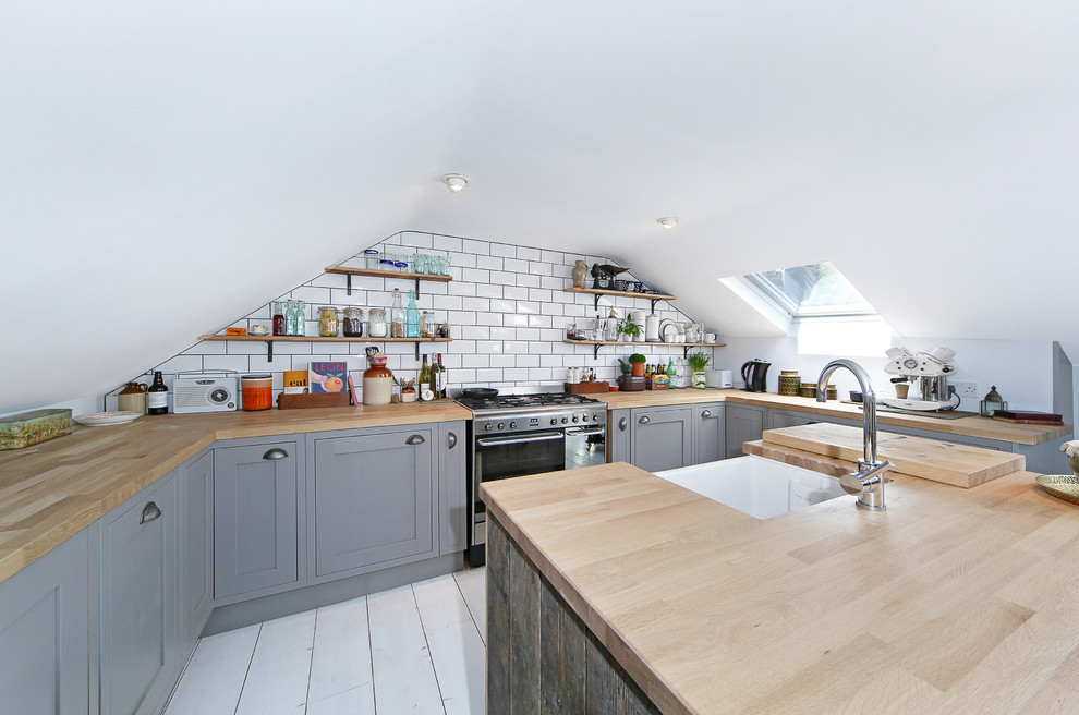 Kleine Industrial Wohnküche in U-Form mit Landhausspüle, grauen Schränken, Küchengeräten aus Edelstahl, hellem Holzboden, Kücheninsel und Arbeitsplatte aus Holz in London