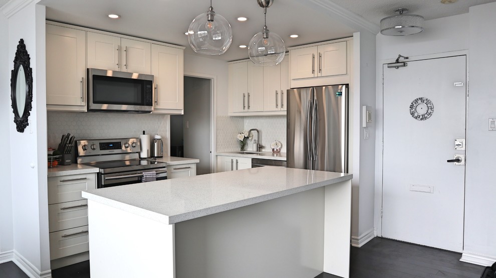 Mid-sized l-shaped dark wood floor and black floor eat-in kitchen photo in Toronto with a single-bowl sink, shaker cabinets, white cabinets, quartz countertops, white backsplash, ceramic backsplash, stainless steel appliances, an island and white countertops