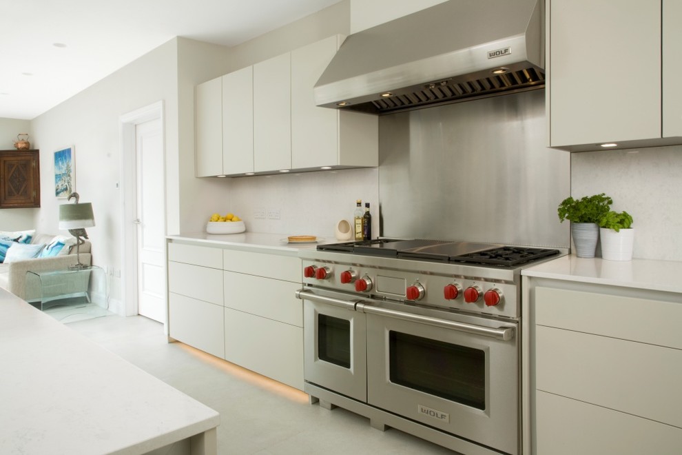 This is an example of a large contemporary u-shaped kitchen/diner in Hertfordshire with a double-bowl sink, flat-panel cabinets, grey cabinets, quartz worktops, white splashback, stone slab splashback, stainless steel appliances, ceramic flooring, an island, white floors and white worktops.