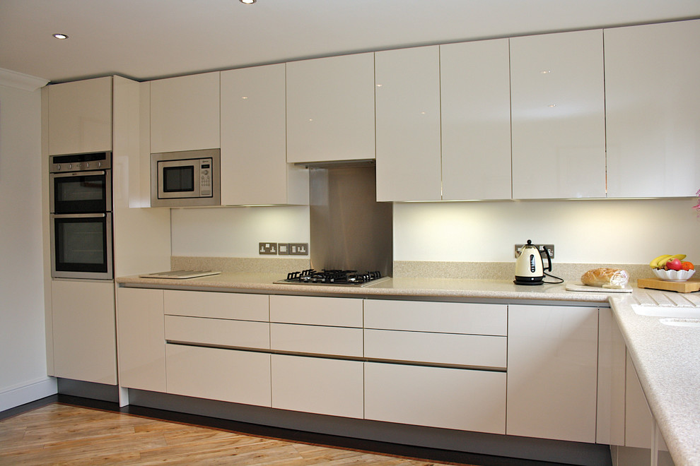 Modelo de cocinas en L minimalista de tamaño medio con puertas de armario blancas