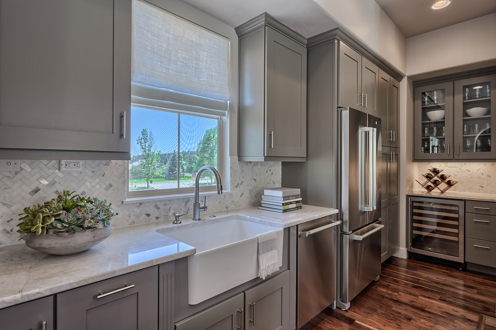 Eat-in kitchen - modern l-shaped medium tone wood floor and brown floor eat-in kitchen idea in Denver with a farmhouse sink, shaker cabinets, gray cabinets, marble countertops, beige backsplash, mosaic tile backsplash, stainless steel appliances and an island