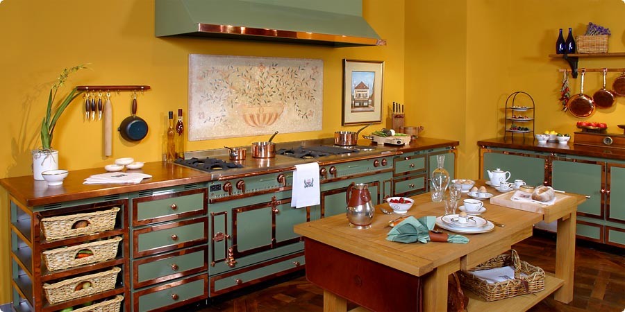 На фото: отдельная кухня в классическом стиле с фасадами с утопленной филенкой, зелеными фасадами, столешницей из меди, цветной техникой, темным паркетным полом, островом и коричневым полом