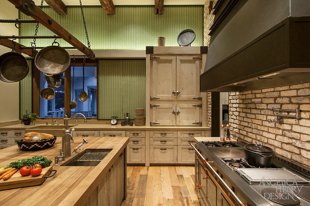 Foto di una cucina stile rurale con ante beige, top in cemento, elettrodomestici da incasso e parquet chiaro