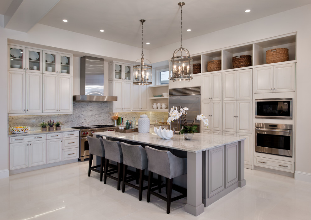 Huge transitional l-shaped porcelain tile open concept kitchen photo in Tampa with white cabinets, granite countertops, gray backsplash, stone slab backsplash, stainless steel appliances and an island