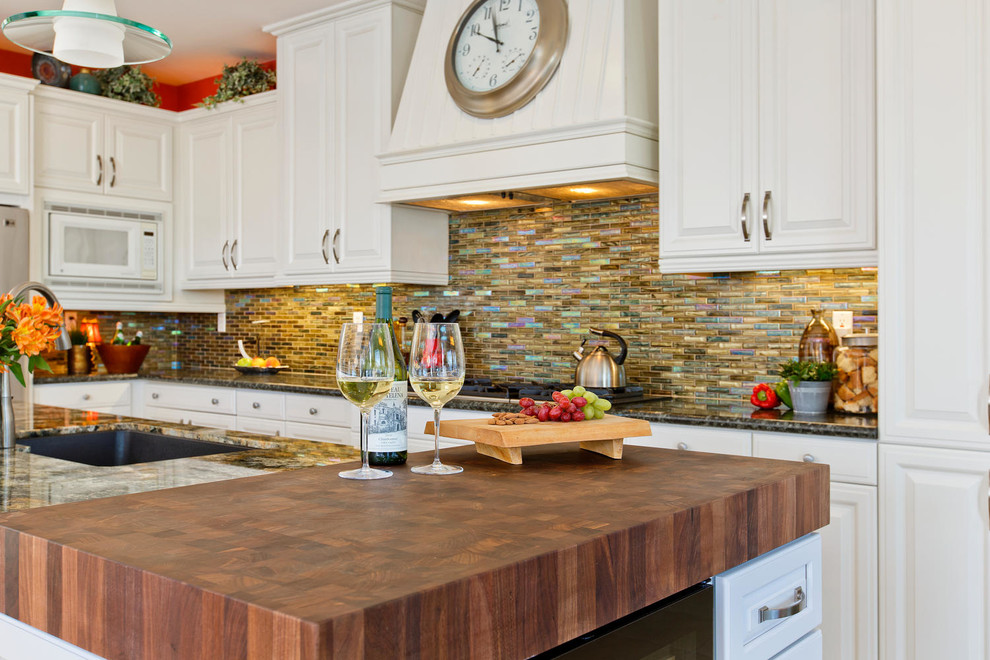 Transitional u-shaped beige floor kitchen photo in San Diego with raised-panel cabinets, white cabinets, wood countertops, multicolored backsplash, matchstick tile backsplash, stainless steel appliances and an island
