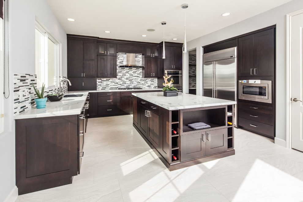 Inspiration for a mid-sized modern u-shaped porcelain tile kitchen remodel in San Diego with an undermount sink, shaker cabinets, dark wood cabinets, marble countertops, multicolored backsplash, matchstick tile backsplash, stainless steel appliances and an island