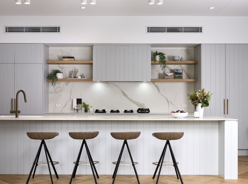Inspiration for a contemporary galley kitchen in Brisbane with grey cabinets, grey splashback, integrated appliances, light hardwood flooring, an island, beige floors and white worktops.