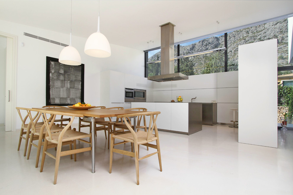 Exempel på ett mycket stort modernt kök, med släta luckor, vita skåp, rostfria vitvaror, en köksö, bänkskiva i rostfritt stål och vitt stänkskydd