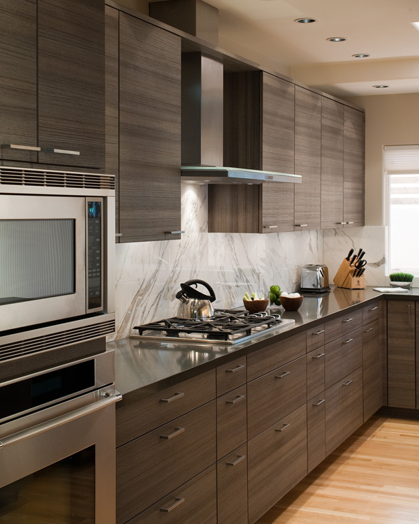 Exempel på ett modernt kök och matrum, med en undermonterad diskho, släta luckor, skåp i mörkt trä, marmorbänkskiva, grått stänkskydd, stänkskydd i sten, rostfria vitvaror och ljust trägolv