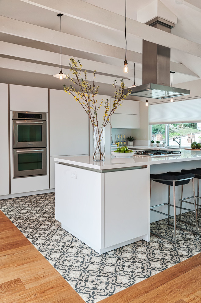 Example of a mid-sized trendy u-shaped concrete floor open concept kitchen design in San Diego with a single-bowl sink, flat-panel cabinets, white cabinets, quartz countertops, white backsplash, stainless steel appliances and no island