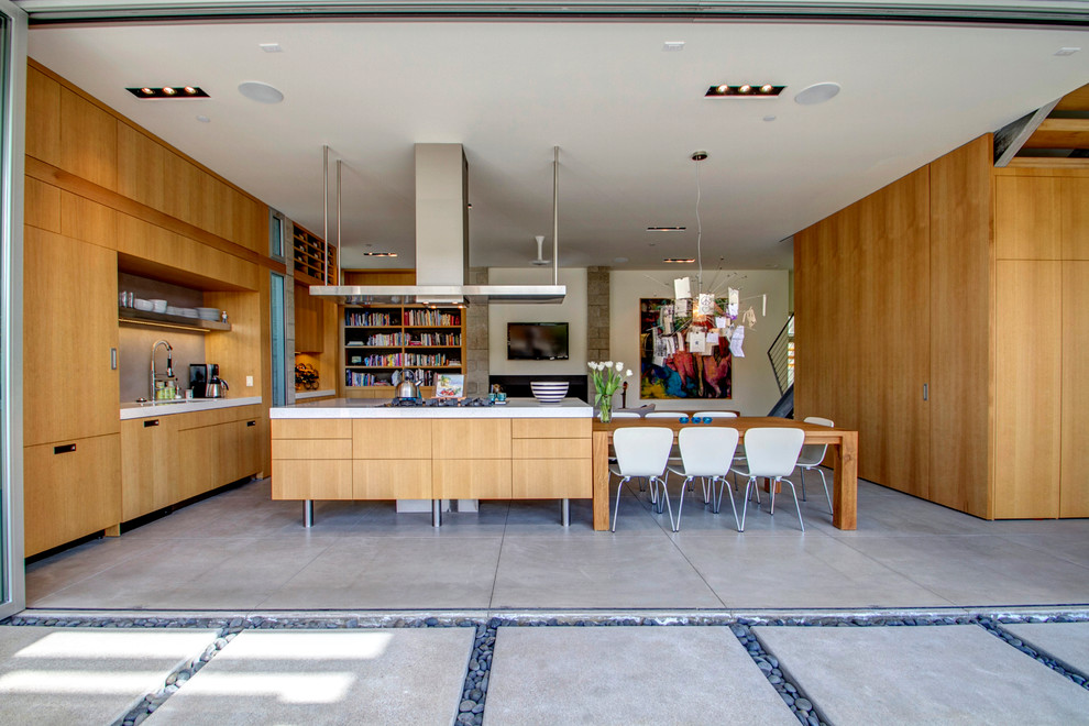 Foto på ett funkis linjärt kök med öppen planlösning, med släta luckor, integrerade vitvaror, betonggolv och en köksö