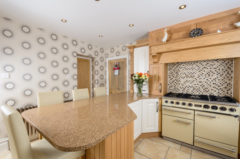 Example of a classic kitchen design in Manchester with mosaic tile backsplash, white appliances and brown backsplash