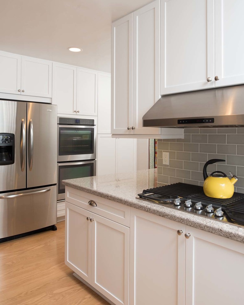 Example of a large classic l-shaped light wood floor eat-in kitchen design in San Diego with an undermount sink, shaker cabinets, white cabinets, quartz countertops, gray backsplash, subway tile backsplash, stainless steel appliances and no island