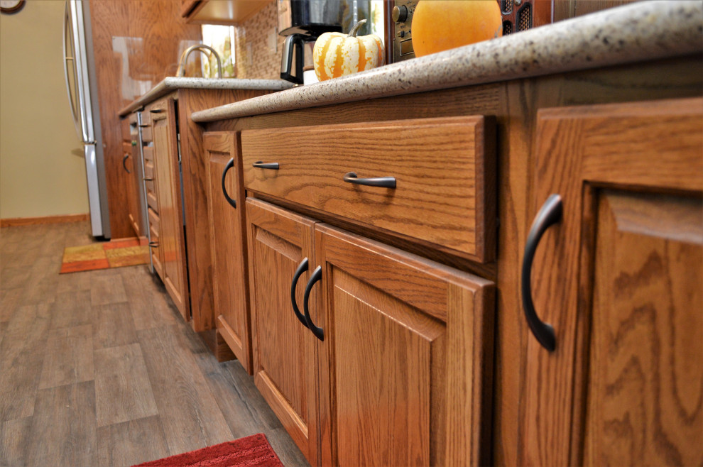 Exempel på ett mellanstort rustikt beige beige kök, med en undermonterad diskho, luckor med upphöjd panel, skåp i mellenmörkt trä, bänkskiva i kvartsit, flerfärgad stänkskydd, rostfria vitvaror, laminatgolv och brunt golv