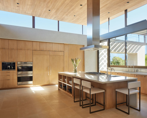 Modern best kitchen cabinet colors Canada design with light wood cabinets, large island with built-in seating, stainless steel appliances, and expansive windows bringing in natural light.