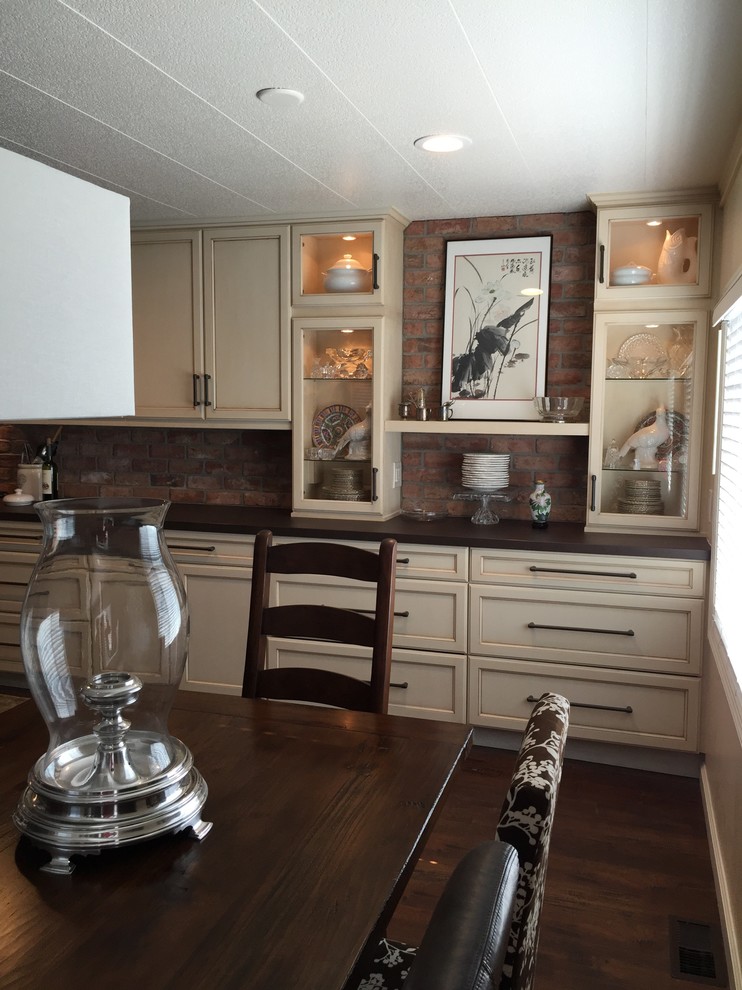 Bild på ett mellanstort linjärt kök med öppen planlösning, med en enkel diskho, luckor med infälld panel, skåp i slitet trä, bänkskiva i kvartsit, rött stänkskydd, stänkskydd i tunnelbanekakel, svarta vitvaror, mörkt trägolv och en köksö