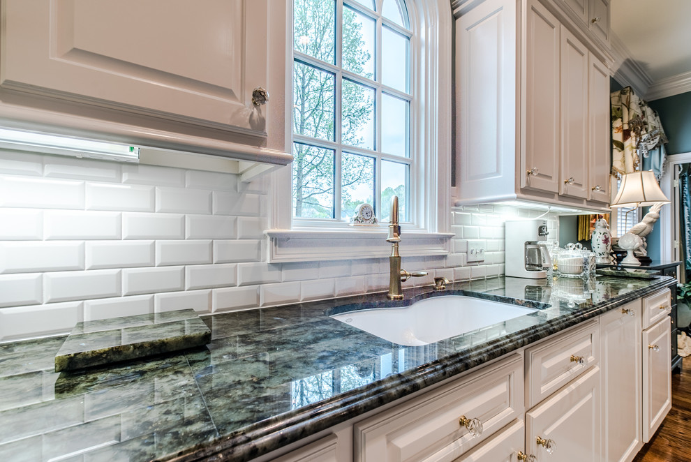 Inspiration for a huge timeless galley light wood floor open concept kitchen remodel in Other with a double-bowl sink, raised-panel cabinets, white cabinets, quartzite countertops, white backsplash, subway tile backsplash, white appliances and an island
