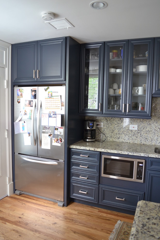 Inspiration for a mid-sized timeless galley light wood floor kitchen remodel in St Louis with an undermount sink, flat-panel cabinets, blue cabinets, granite countertops, multicolored backsplash, stone slab backsplash, stainless steel appliances and a peninsula