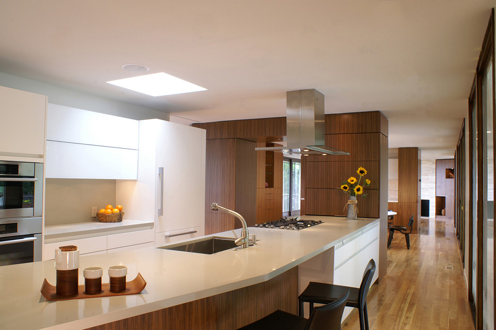Moderne Küche mit Waschbecken, flächenbündigen Schrankfronten, weißen Schränken, Küchenrückwand in Grau und Elektrogeräten mit Frontblende in New York