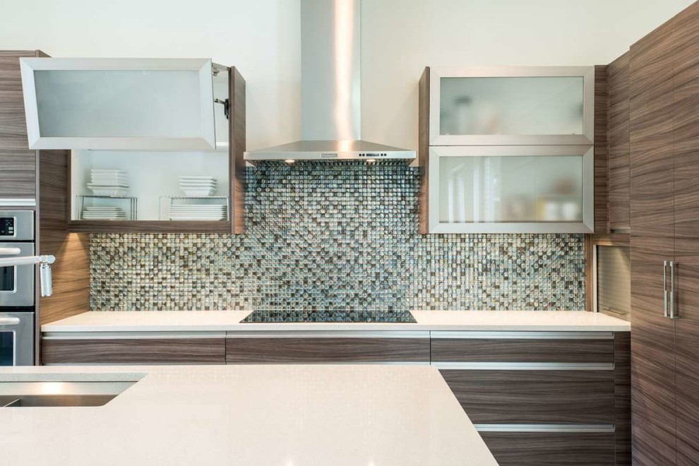 Bild på ett mellanstort funkis kök och matrum, med släta luckor, bruna skåp, bänkskiva i kvartsit, blått stänkskydd och stänkskydd i glaskakel