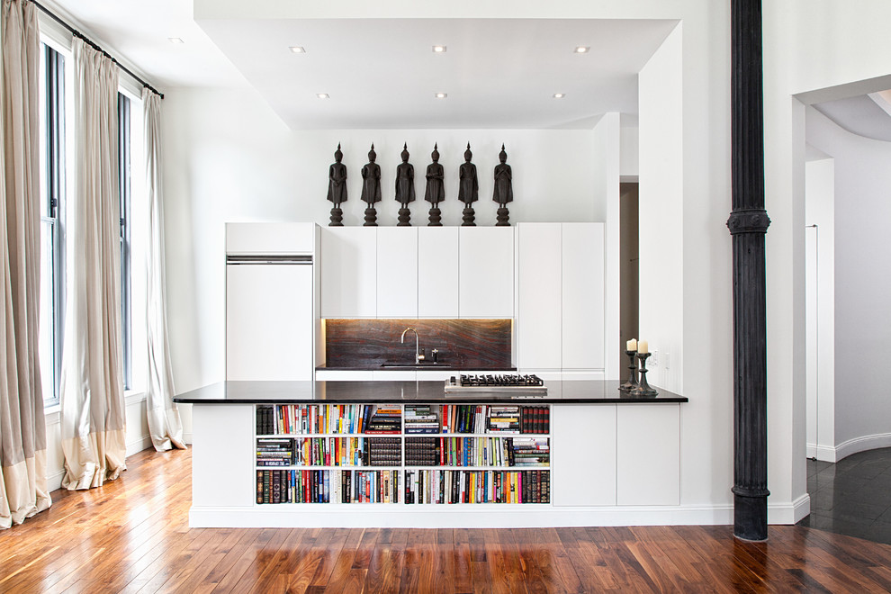 Zweizeilige Moderne Küche mit flächenbündigen Schrankfronten, weißen Schränken, Küchenrückwand in Schwarz, Rückwand aus Stein und weißen Elektrogeräten in New York