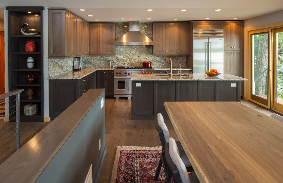 This is an example of a contemporary kitchen in Minneapolis with grey cabinets, granite worktops, multi-coloured splashback, stone slab splashback, stainless steel appliances, medium hardwood flooring and an island.