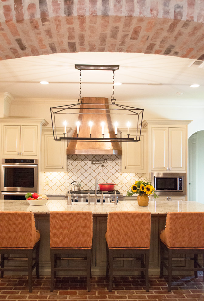 Bild på ett mellanstort amerikanskt kök, med en rustik diskho, luckor med upphöjd panel, vita skåp, granitbänkskiva, vitt stänkskydd, stänkskydd i porslinskakel, rostfria vitvaror, tegelgolv och en köksö