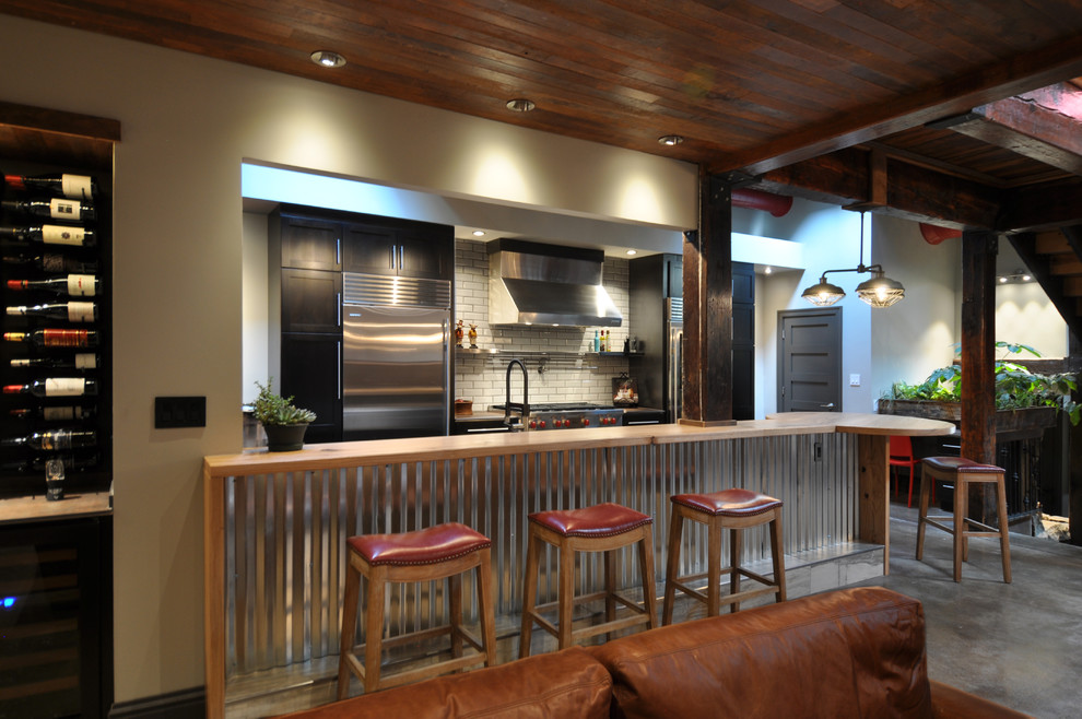 セントルイスにある高級な広いインダストリアルスタイルのおしゃれなキッチン (シェーカースタイル扉のキャビネット、濃色木目調キャビネット、木材カウンター、白いキッチンパネル、サブウェイタイルのキッチンパネル、エプロンフロントシンク、シルバーの調理設備、コンクリートの床、グレーの床) の写真