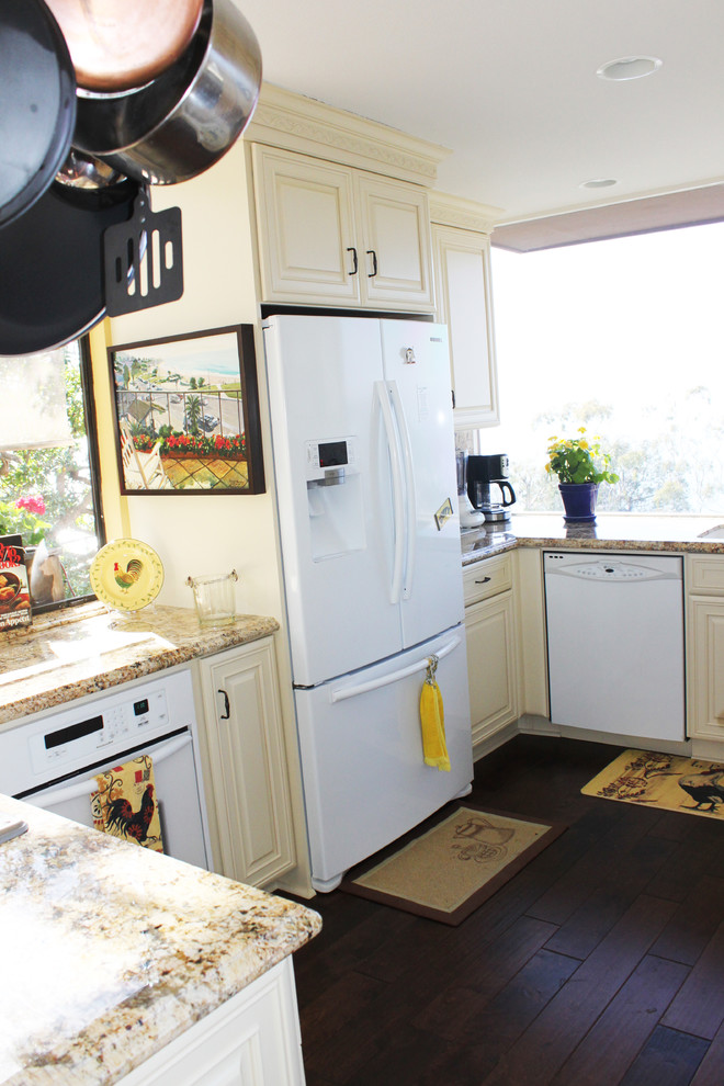 Foto på ett litet vintage kök, med en undermonterad diskho, luckor med upphöjd panel, gula skåp, granitbänkskiva, beige stänkskydd, stänkskydd i sten, vita vitvaror och mellanmörkt trägolv