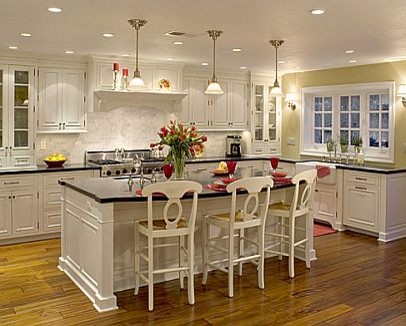 Large elegant u-shaped medium tone wood floor eat-in kitchen photo in Los Angeles with raised-panel cabinets, white cabinets, an island, a farmhouse sink, granite countertops, white backsplash, subway tile backsplash and stainless steel appliances